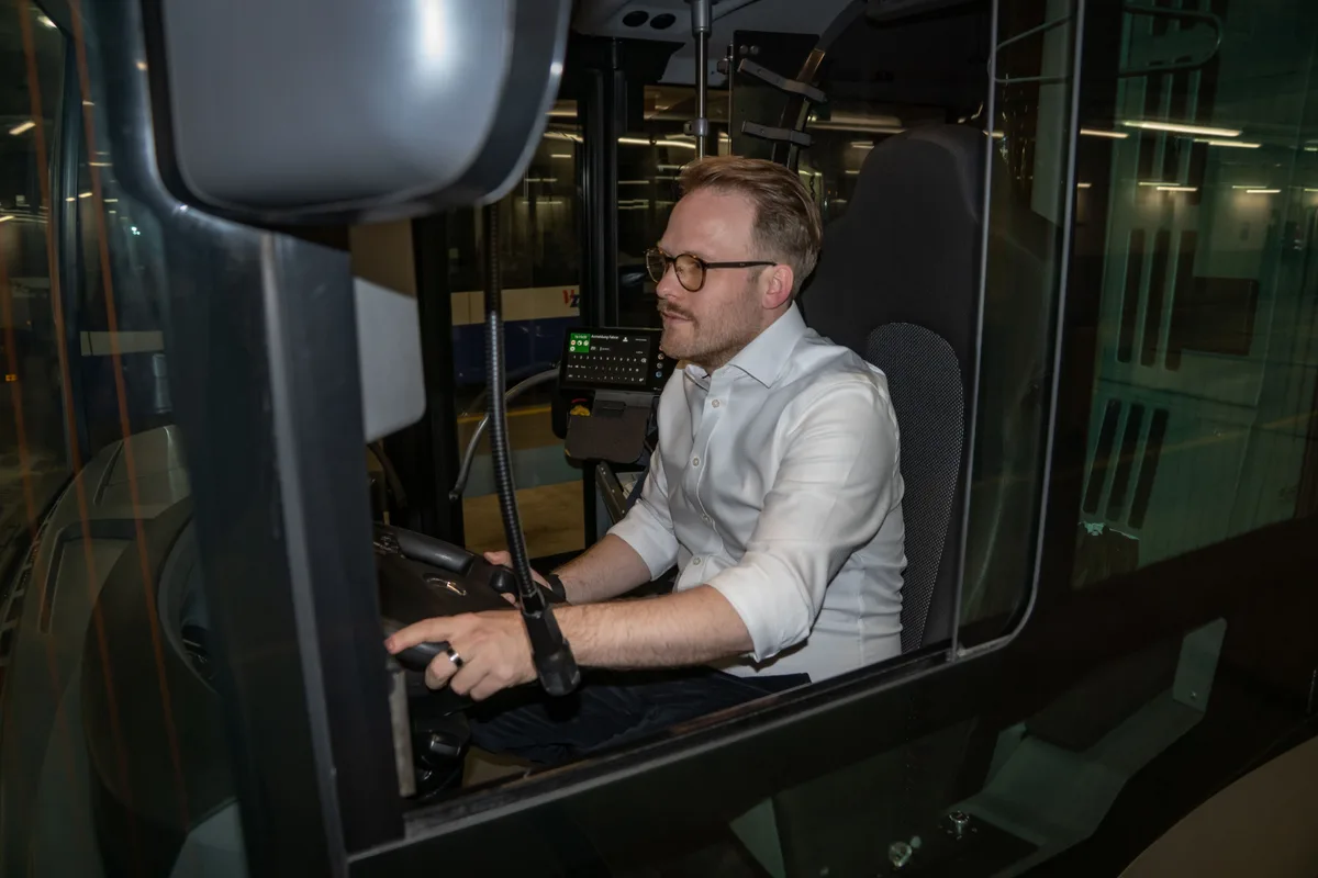 Man sieht einen Mann am Steuerrad eines Busses.